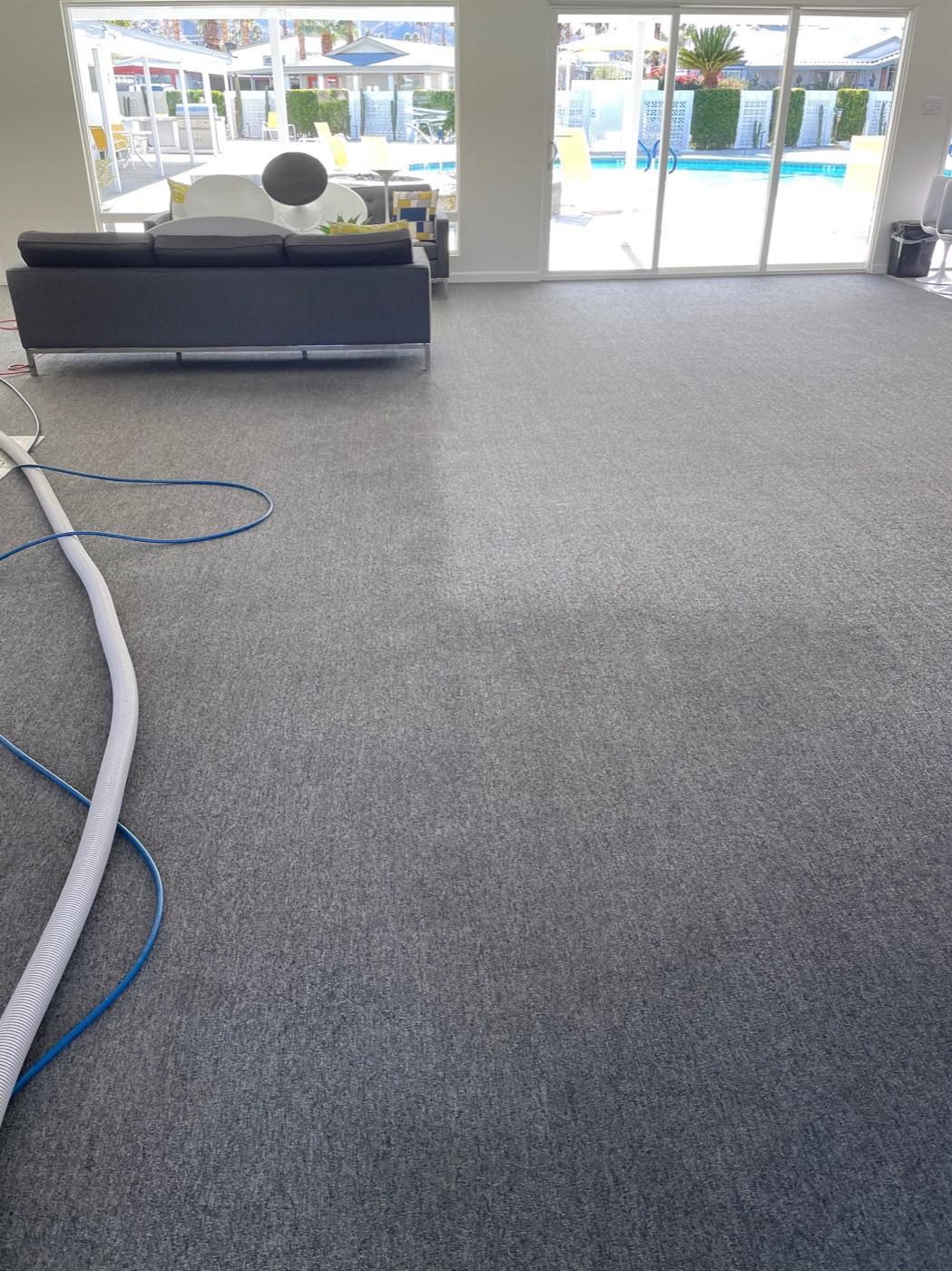 Professional carpet cleaning in progress inside a bright mid-century clubhouse lounge
