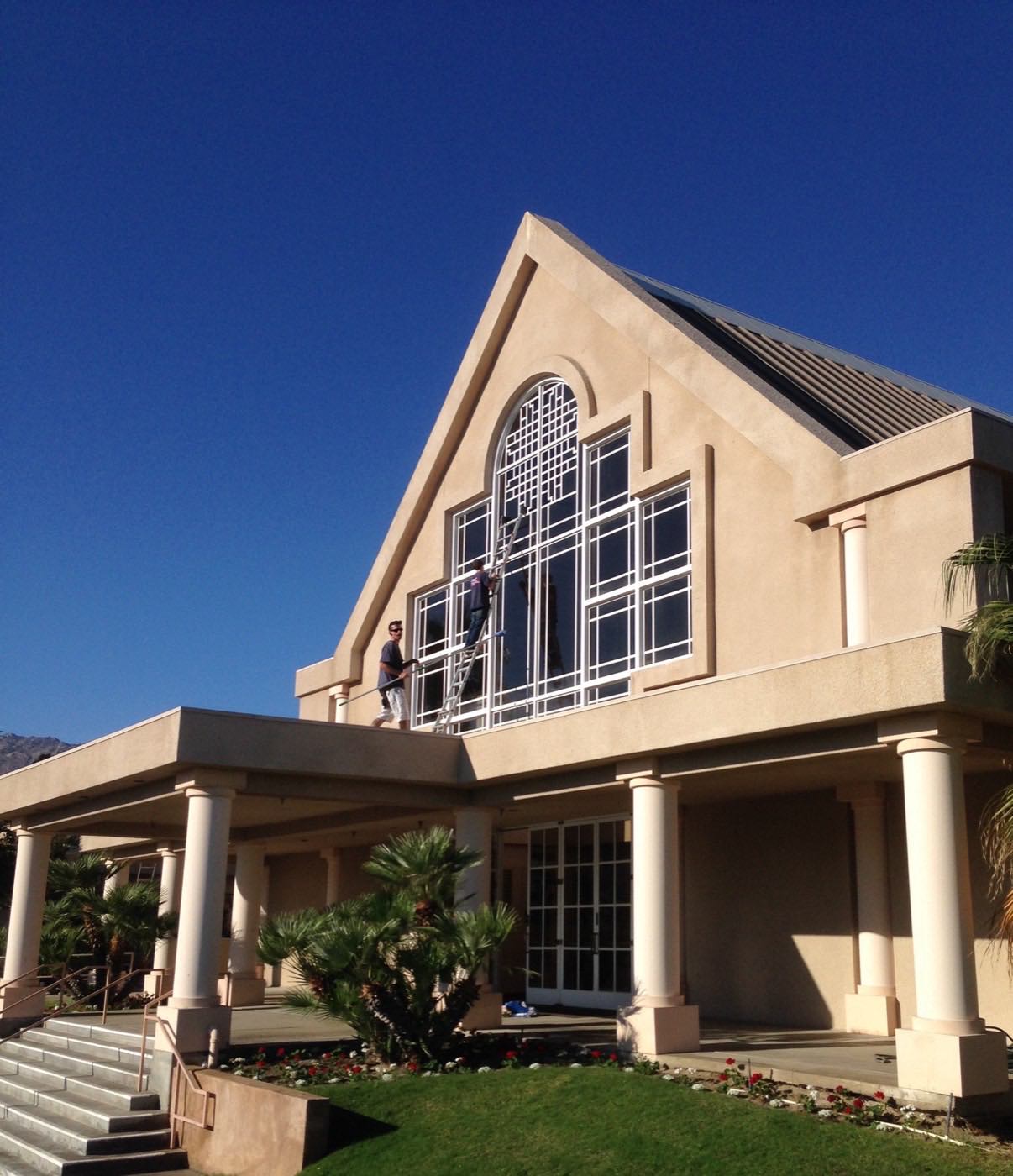 Crew detailing a dramatic two-story arched window wall on a commercial building